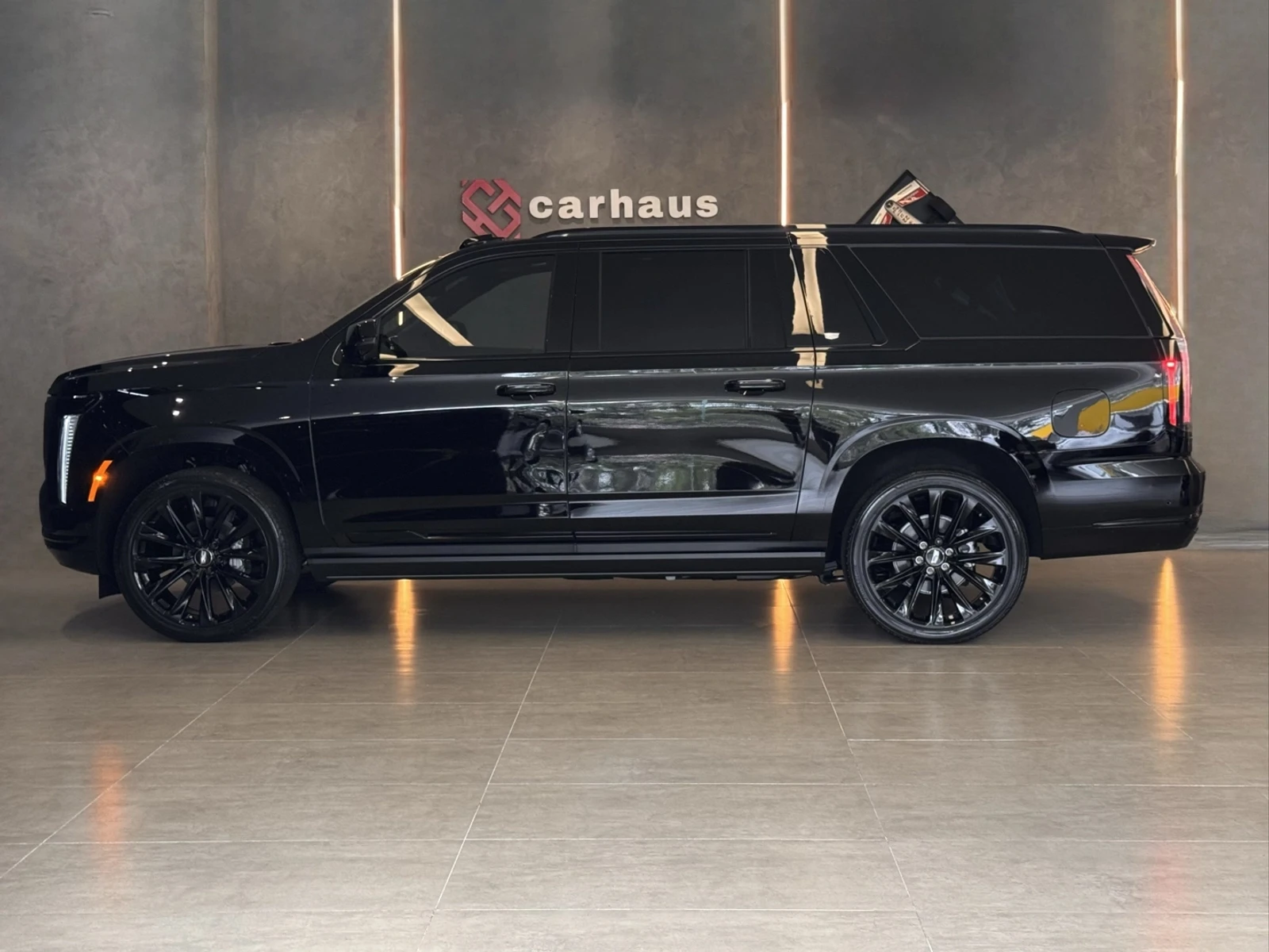Lateral do Cadillac Escalade ESV Sport preto no showroom Carhaus
